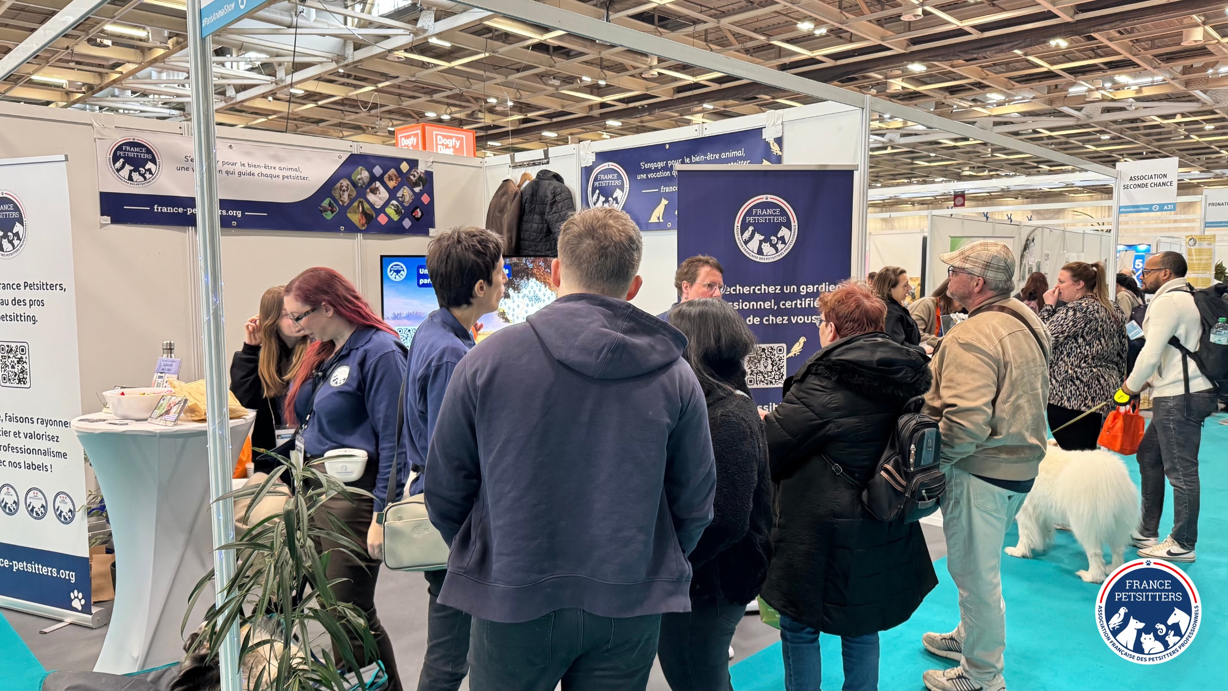 Le stand de France Petsitters sur un salon, entouré de visiteurs